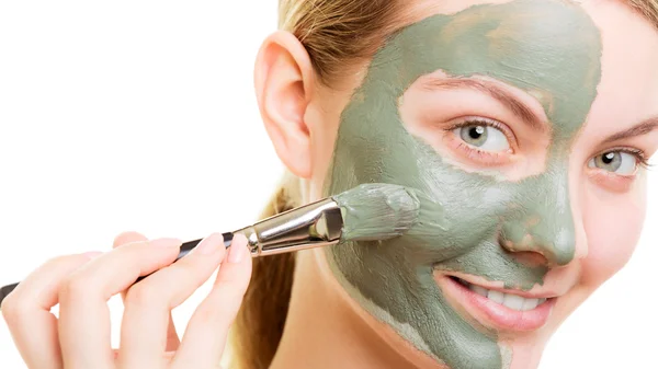 Woman applying with brush clay mud mask her face — Stock Photo, Image