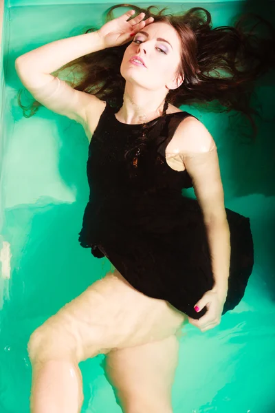 Sexy mulher sedutora em vestido preto na água . — Fotografia de Stock