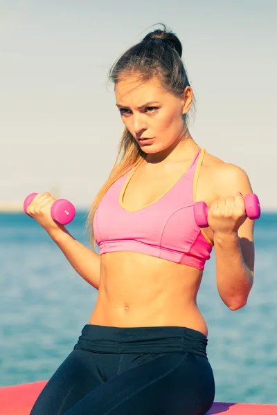 Vrouw doet sport buitenshuis met halters — Stockfoto