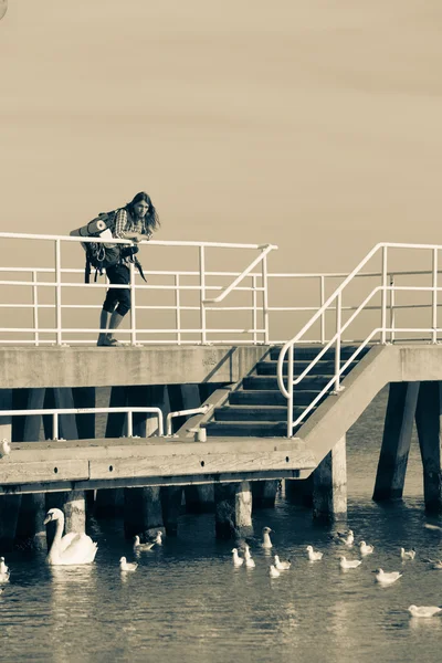 Hombre excursionista con mochila en el muelle, paisaje marino — Foto de Stock