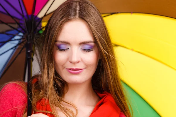 Woman standing under multicolored umbrella — Stock Photo, Image