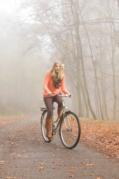 Active woman riding bike bicycle in autumn park. — Stock Photo, Image