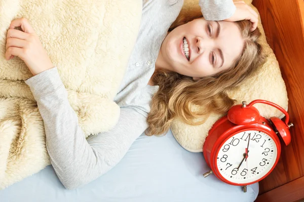 Woman waking up turning off alarm clock in morning — Stock Photo, Image