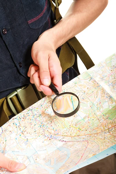 Tourist reading map with magnifying glass — Stock Photo, Image