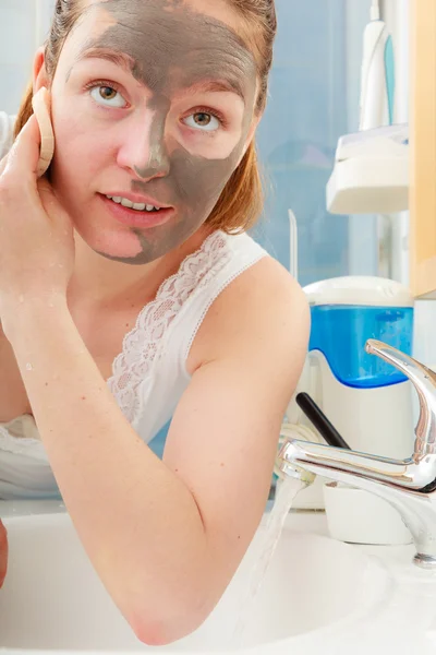 Mujer quitar la máscara de barro facial en el baño —  Fotos de Stock