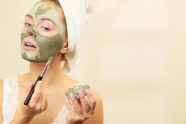 Femme appliquant avec un masque de boue d'argile brosse sur son visage — Photo