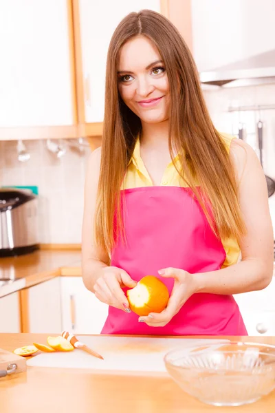 Mulher descascada laranja fruta com faca — Fotografia de Stock