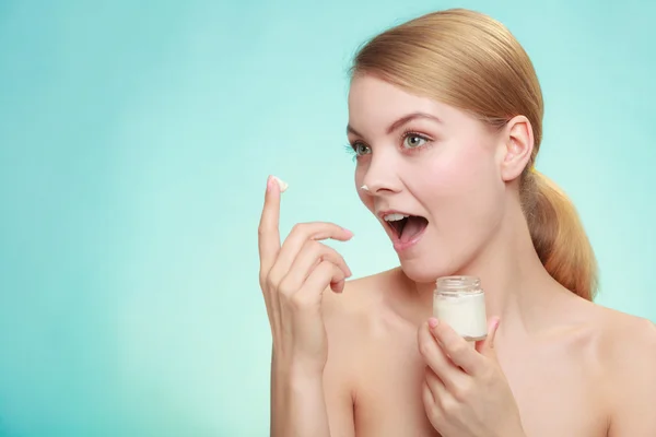 Mujer aplicando crema en su cara de piel. —  Fotos de Stock