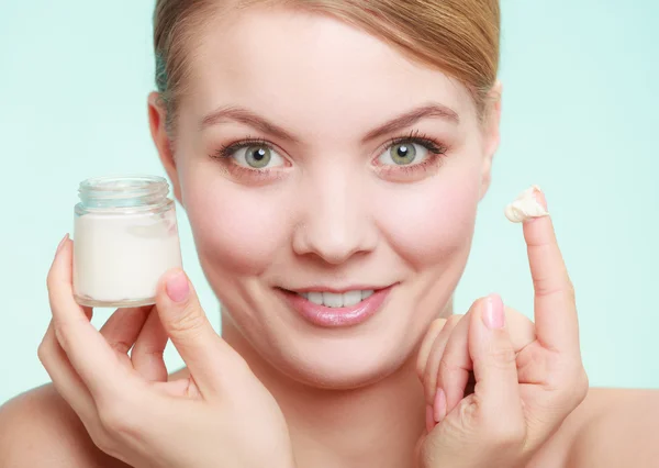 Mujer aplicando crema en su cara de piel. —  Fotos de Stock