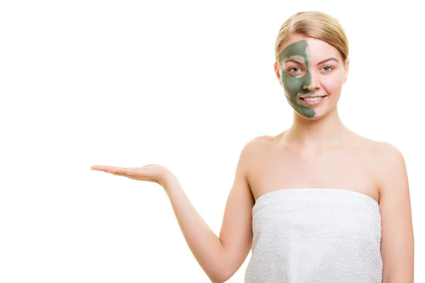 Kobieta w gliny błotem maski na twarzy trzyma otwartej dłoni — Zdjęcie stockowe