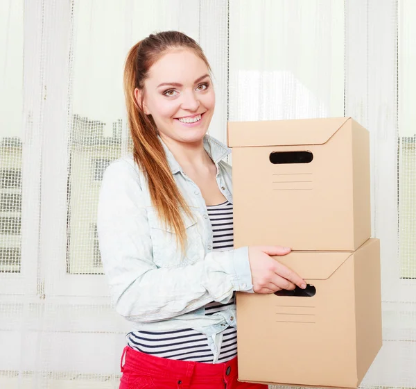 Happy woman moving into house carrying boxes. — Stock Photo, Image