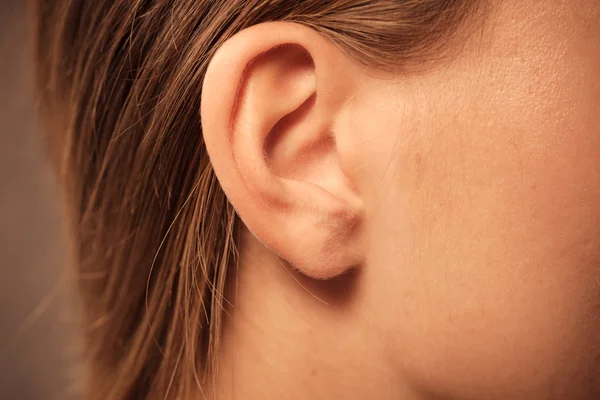 Primer plano en la oreja femenina — Foto de Stock