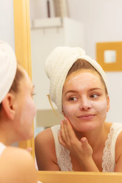 Mujer aplicando crema mascarilla en la cara en el baño — Foto de Stock