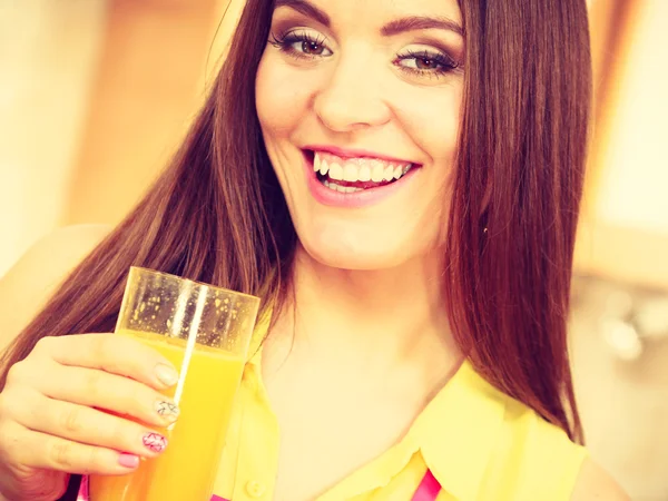 Frau in Küche trinkt frischen Orangensaft — Stockfoto