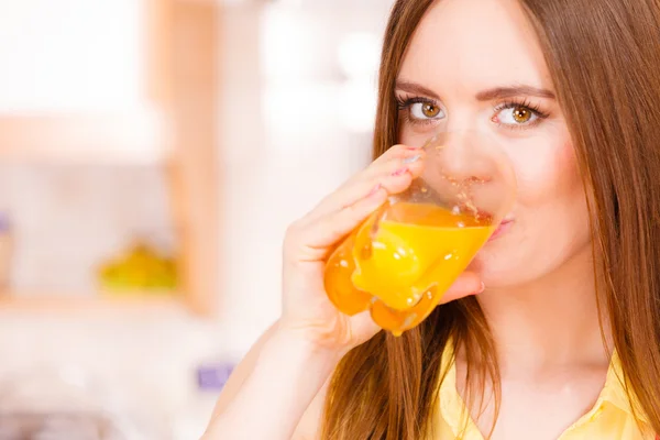 Wanita di dapur minum jus jeruk segar — Stok Foto