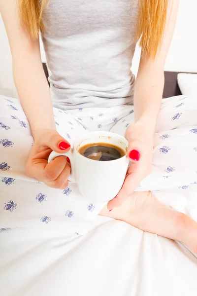 Kobieta na łóżku z filiżanką kawy — Zdjęcie stockowe