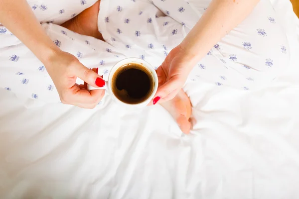 Woman on bed with cup of coffee — Stock Photo, Image
