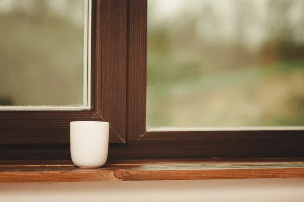 Weißer Tee- oder Kaffeebecher am Fenster — Stockfoto