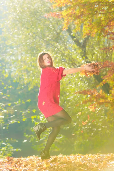 Jovem mulher jogando folhas . — Fotografia de Stock