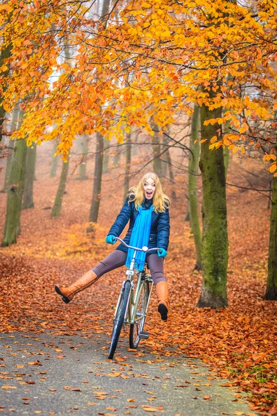 Feliz mulher ativa andar de bicicleta no parque de outono . — Fotografia de Stock