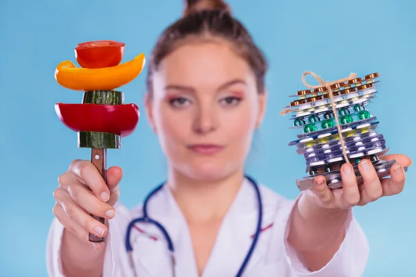 Vrouw met dieetpillen van het gewichtsverlies en groenten. — Stockfoto