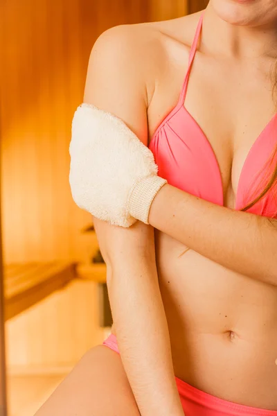 Closeup of woman in sauna with exfoliating glove. — Stock Photo, Image