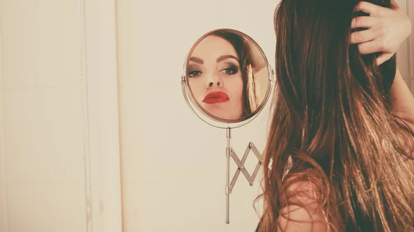 Молодая девушка смотрит в зеркало . — стоковое фото