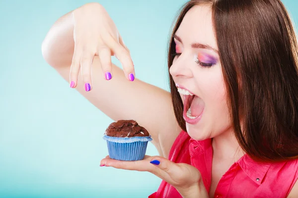 Smiling woman holds chocolate cake in hand — Stock Photo, Image