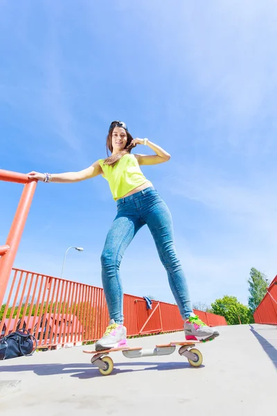 Dospívající dívka bruslař na koni skateboard na ulici. — Stock fotografie