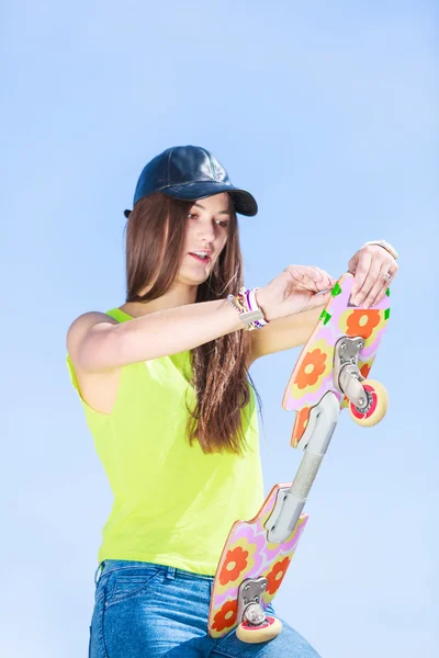 Teen girl skater mit skateboard auf straße. — Stockfoto