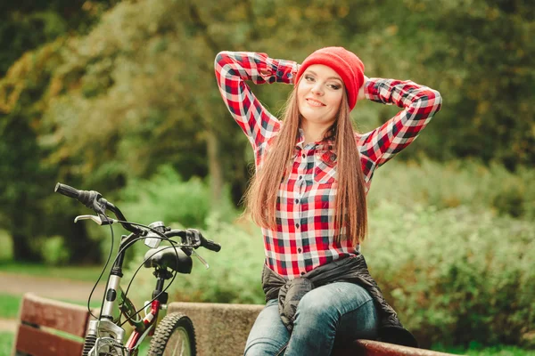 Flicka avkopplande i höst park med cykel. — Stockfoto