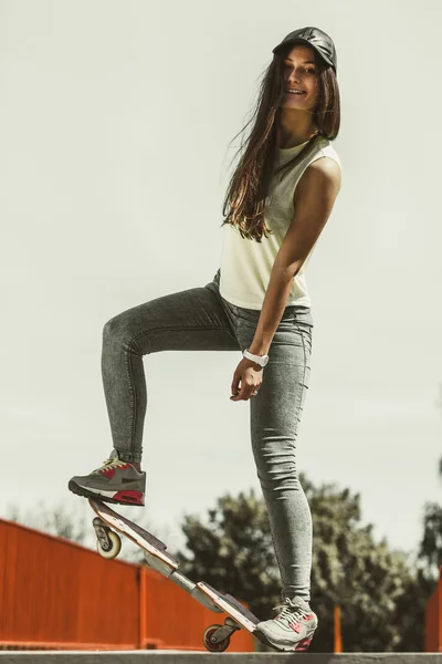 Dospívající dívka bruslař na koni skateboard na ulici. — Stock fotografie