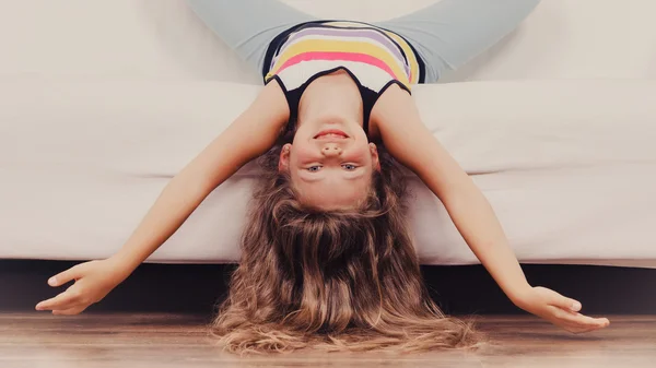 Little girl kid with long hair upside down on sofa — Stock Photo, Image