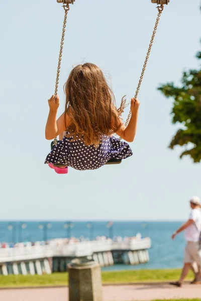 Chica balanceándose en swing-set . — Foto de Stock