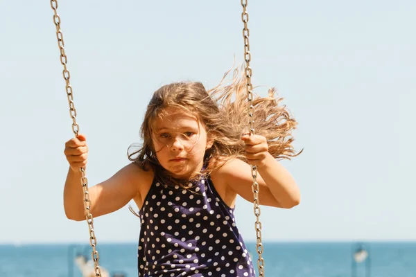 Menina balançando no swing-set . — Fotografia de Stock