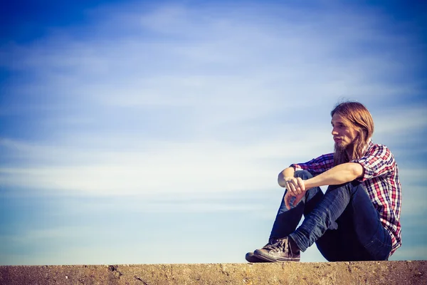 Homem longo cabelo relaxante céu ao ar livre fundo — Fotografia de Stock