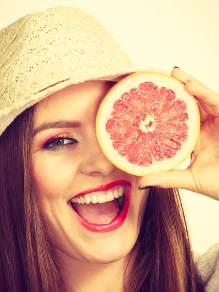Vrouw met de helft van de grapefruit citrusvruchten in de hand — Stockfoto