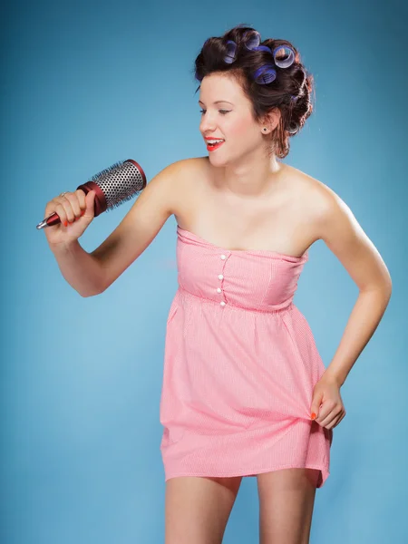 Flicka med papiljotter i håret håller hårborste — Stockfoto