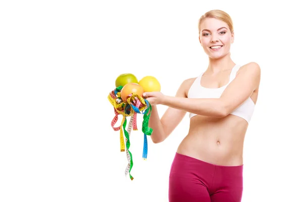 Happy woman holding grapefruits and tape measures. — Stock Photo, Image