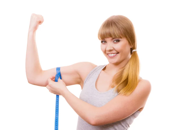 Fit girl with measure tape measuring her biceps — Stock Photo, Image