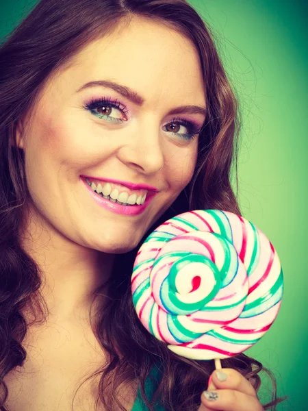 Ragazza sorridente con caramelle lecca lecca sul verde — Foto Stock