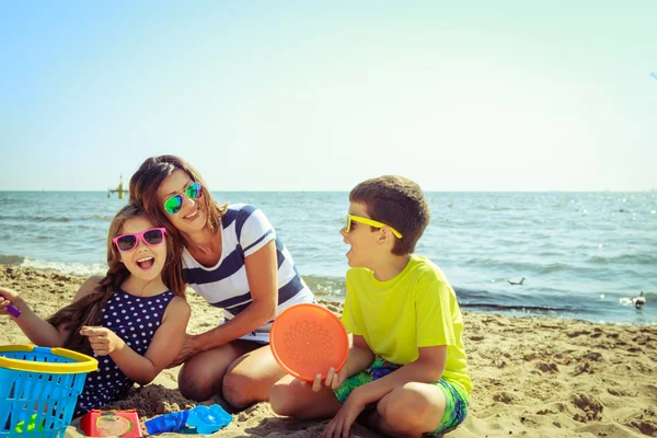 Család anya lánya fia szórakozás a strandon. — Stock Fotó