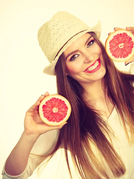 Mulher segura duas metades de frutas cítricas de toranja nas mãos — Fotografia de Stock