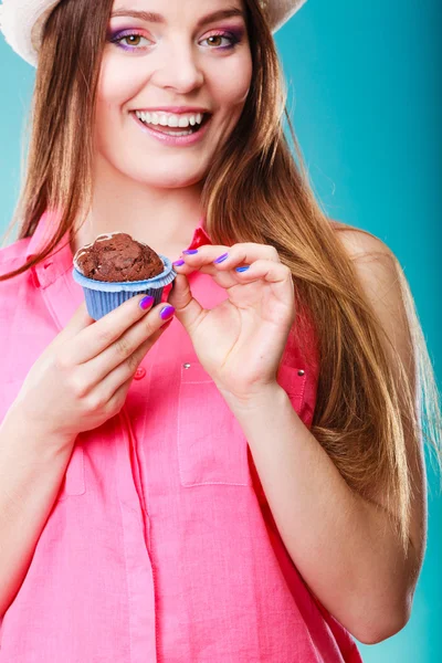 Mulher sorridente segura bolo de chocolate na mão — Fotografia de Stock