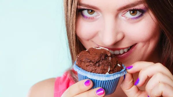 Smiling woman holds chocolate cake in hand — Stock Photo, Image