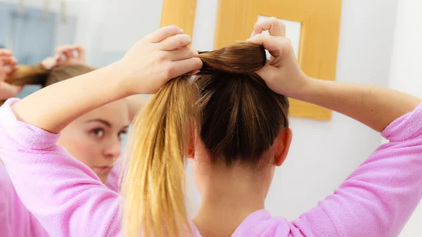 Femme peigner ses cheveux longs dans la salle de bain — Photo