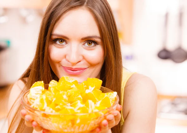 Женщина держит чашу, полную нарезанных апельсиновых фруктов — стоковое фото