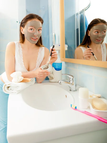 Mujer aplicando máscara facial de barro — Foto de Stock