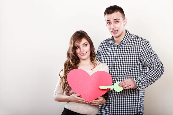 Woman and man holding heart with key — Stockfoto