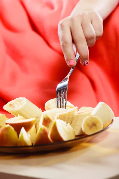 Mani donna prendendo forchetta banana e mela . — Foto Stock